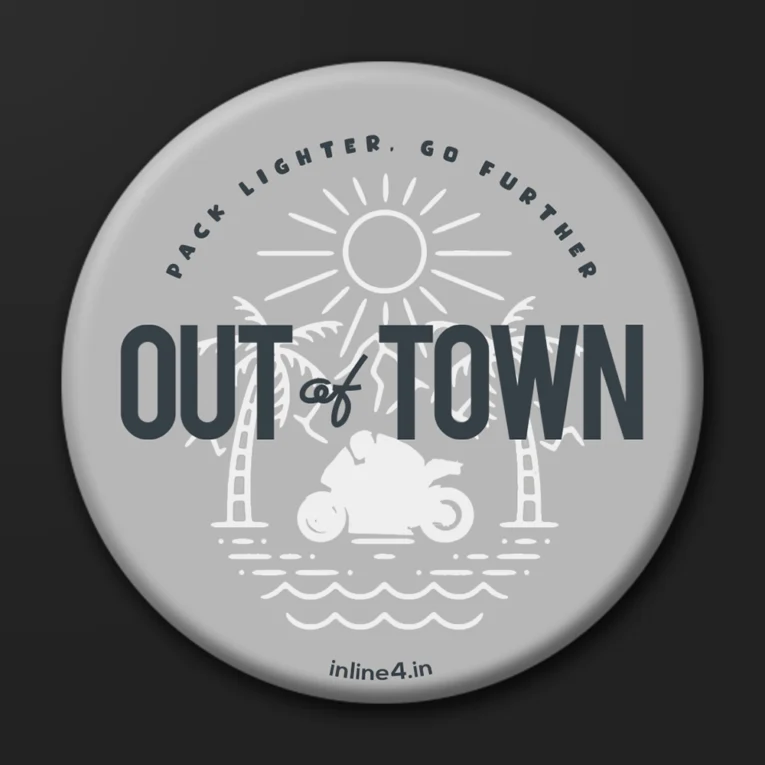 Grey badge with a line illustration of palm trees, sun and waves, a motorcycle silhouette, and bold text reading "Out Of Town"