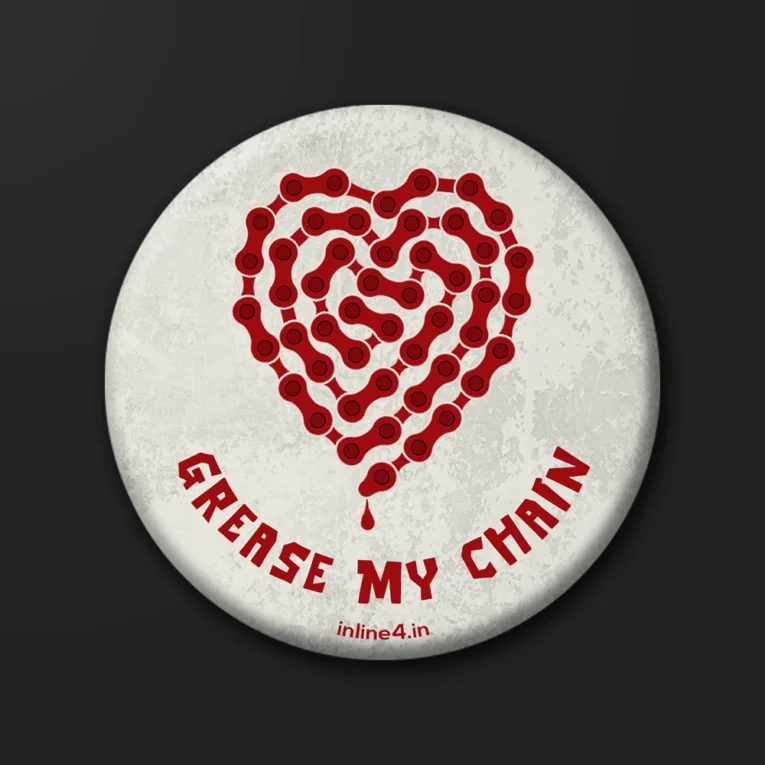 Off-white textured badge with a red motorcycle chain shaped into a dripping heart, "Grease My Chain" text below