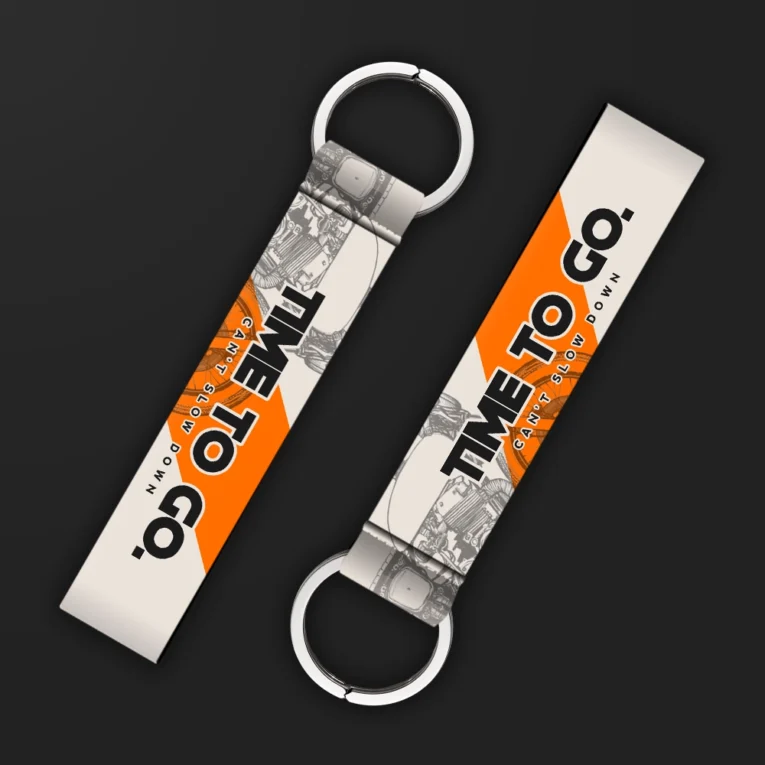 Inline-4 Time to Go keychain strap with black 'TIME TO GO' and orange 'CAN'T SLOW DOWN' text over a sketched engine illustration, double keyring