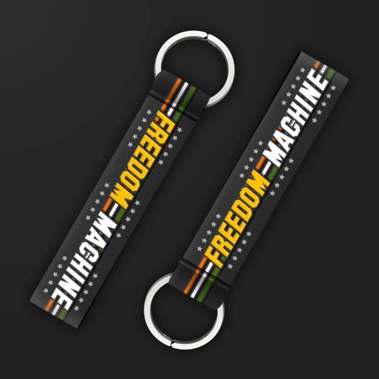 Inline-4 Freedom Machine keychain strap with white and yellow 'FREEDOM MACHINE' text over a star pattern and Indian tricolor stripe, double keyring