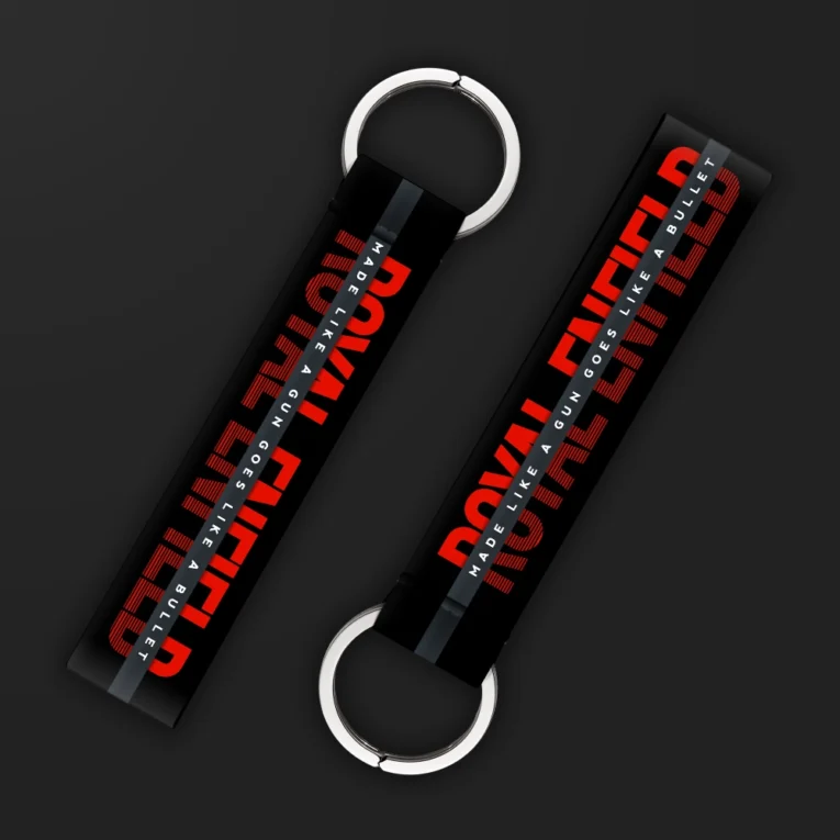 Inline-4 Made like a Gun keychain strap with a bold red 'MADE LIKE A GUN' wordmark on a black textured background, double keyring