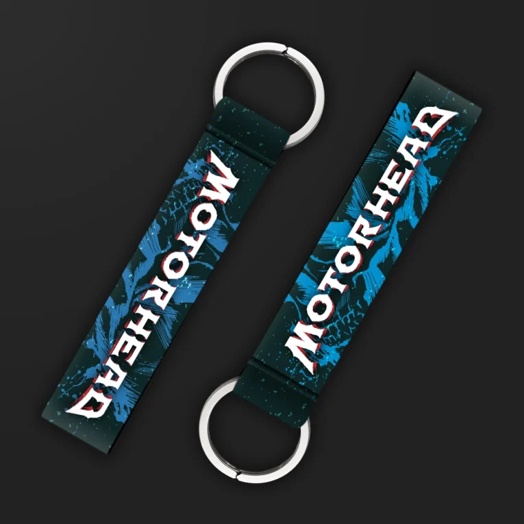 Inline-4 Motorhead keychain strap with a bold white and red 'MOTORHEAD' wordmark over a blue splatter-paint background, double keyring
