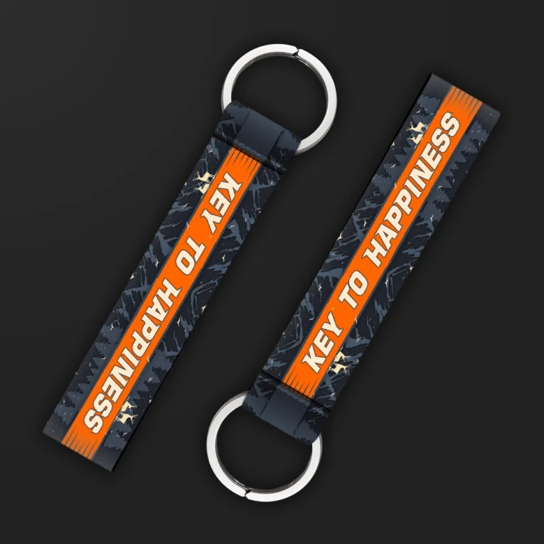 Inline-4 Key to Happiness keychain strap with a bold orange 'KEY TO HAPPINESS' banner over a dark mountain-and-star print, double keyring