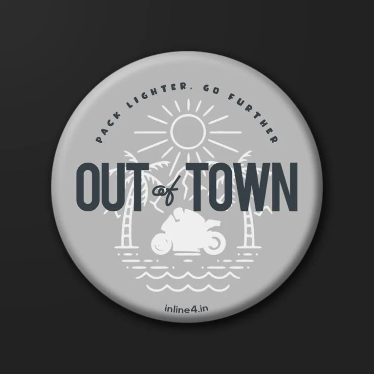 Grey badge with a line illustration of palm trees, sun and waves, a motorcycle silhouette, and bold text reading "Out Of Town"