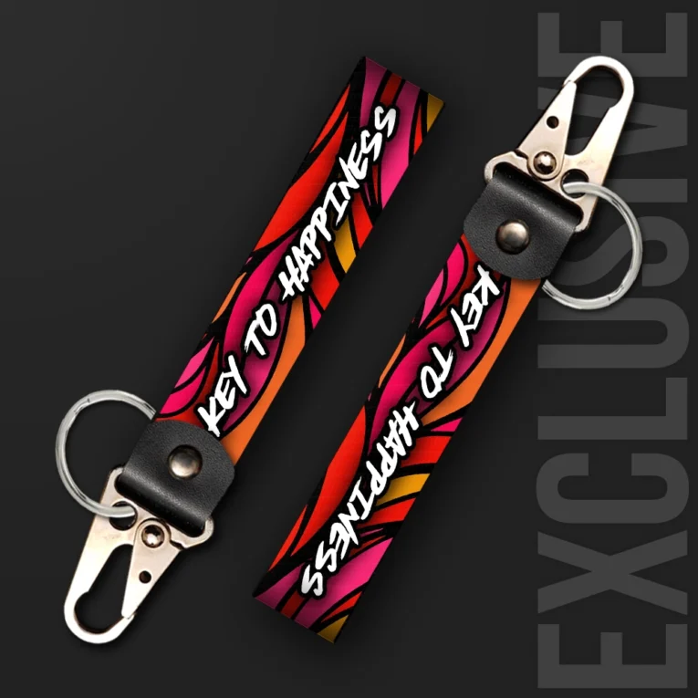 Inline-4 Key to Happiness 2.0 keychain strap with pink and orange flame graphics behind a handwritten 'KEY TO HAPPINESS' script, swivel hook clip + keyring