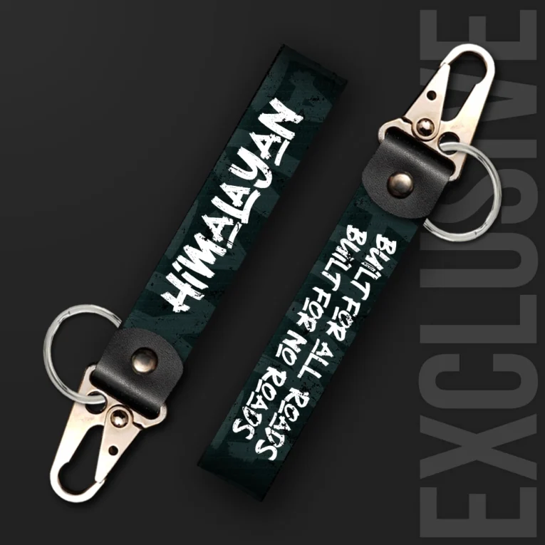Inline-4 Himalayan keychain strap with white 'HIMALAYAN' text and 'BUILT FOR ALL ROADS, BUILT FOR NO ROADS' tagline on a dark green background, swivel hook clip + keyring