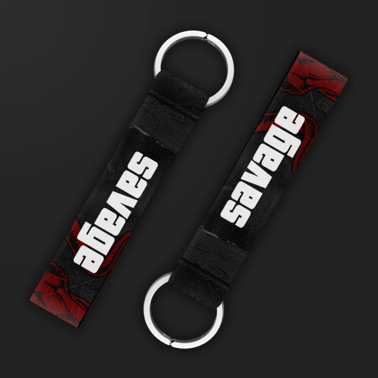 Inline-4 Savage keychain strap with bold white 'SAVAGE' text over a dark red distressed background, double keyring