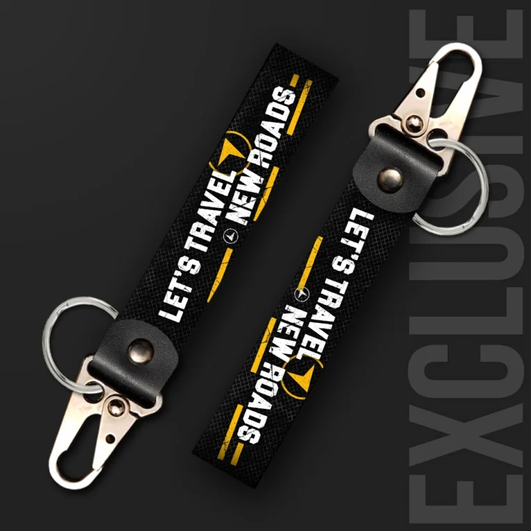 Inline-4 Lets Travel New Roads keychain strap with white 'LET'S TRAVEL NEW ROADS' text and a compass icon on black, swivel hook clip + keyring