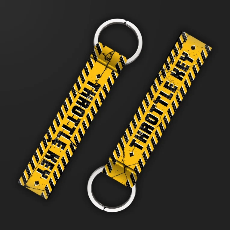 Inline-4 Throttle Key keychain strap with black 'THROTTLE KEY' text over a yellow and black hazard-stripe tire-tread pattern, double keyring