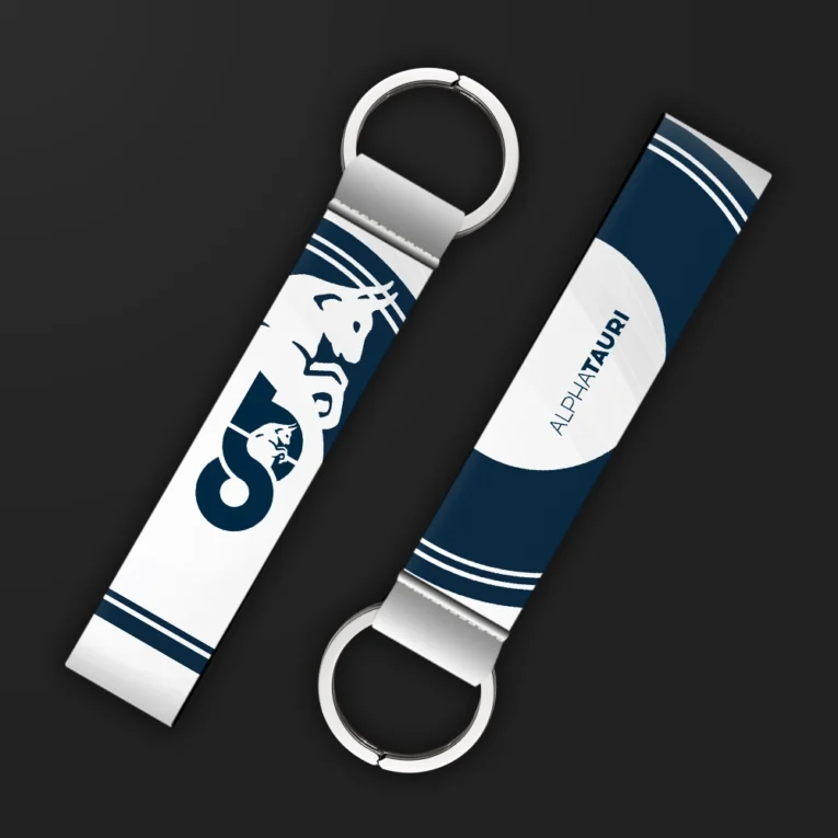 Inline-4 racing tribute keychain strap in navy and white with a bull emblem and racing team wordmark, double keyring