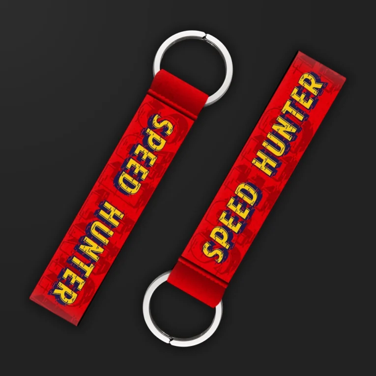 Inline-4 Speed Hunter keychain strap with a vintage red and yellow 'SPEED HUNTER' wordmark on a distressed grille-pattern background, double keyring