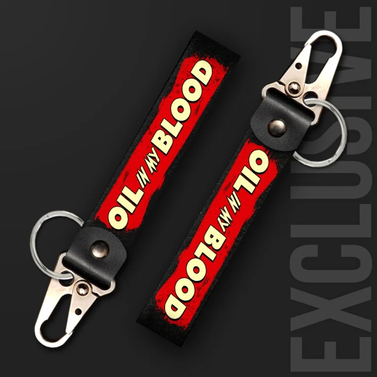 Inline-4 Oil in my Blood keychain strap with a red paint-splash background and cream 'OIL IN MY BLOOD' lettering, swivel hook clip + keyring